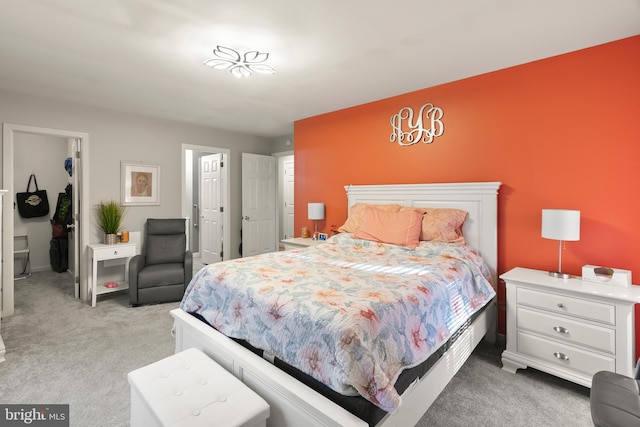 bedroom with light colored carpet, a spacious closet, and a closet