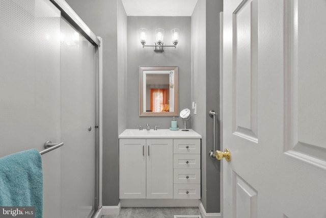 bathroom featuring baseboards, a shower stall, and vanity