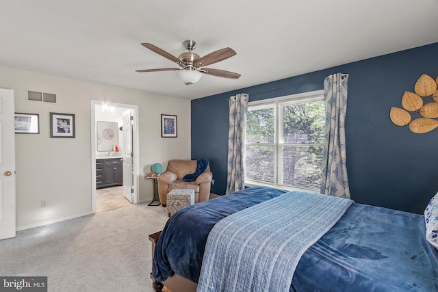 bedroom featuring light carpet, a ceiling fan, baseboards, ensuite bathroom, and visible vents