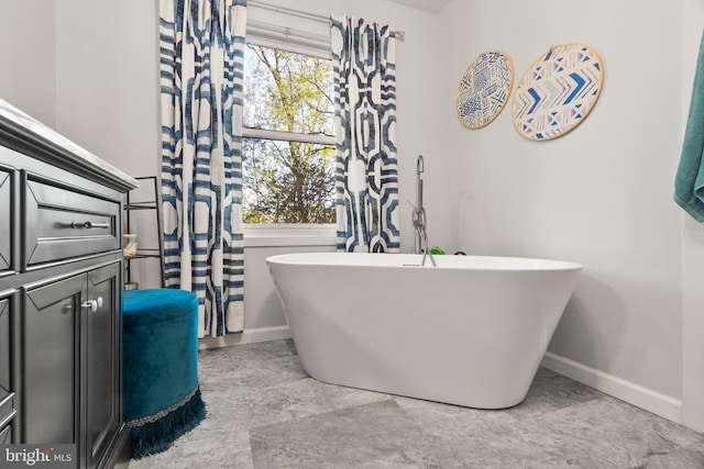 bathroom with baseboards and a freestanding tub
