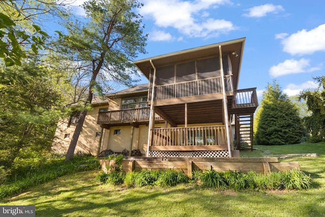 back of house featuring stairs, a sunroom, a wooden deck, and a yard