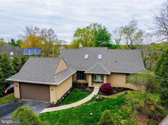 view of front of home with roof with shingles, an attached garage, stucco siding, a front yard, and driveway