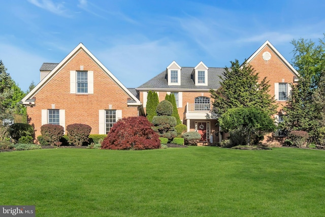view of front facade with a front lawn and brick siding