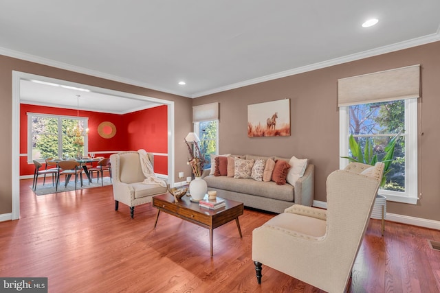 living room featuring baseboards, ornamental molding, recessed lighting, and wood finished floors