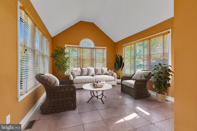 tiled living area featuring visible vents, baseboards, and vaulted ceiling