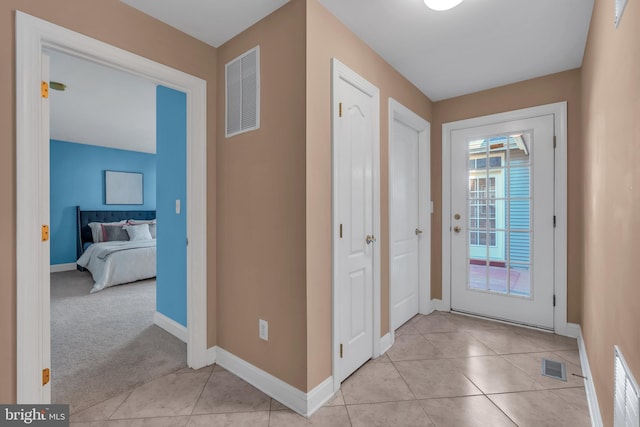 interior space with baseboards, visible vents, and light tile patterned floors