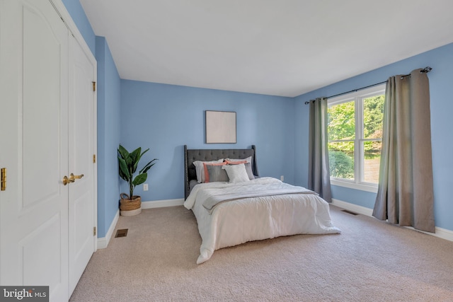 bedroom with visible vents, carpet flooring, and baseboards