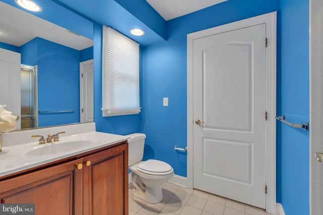 full bath featuring tile patterned flooring, a shower with shower door, baseboards, vanity, and toilet