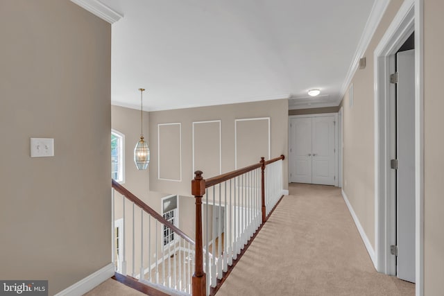 corridor with crown molding, baseboards, an upstairs landing, and carpet flooring