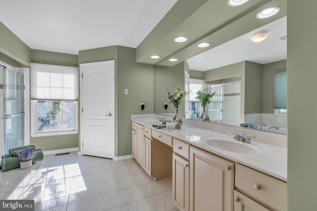bathroom with double vanity, baseboards, a shower stall, and a sink