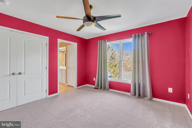 unfurnished bedroom with baseboards, ceiling fan, ensuite bathroom, and carpet flooring