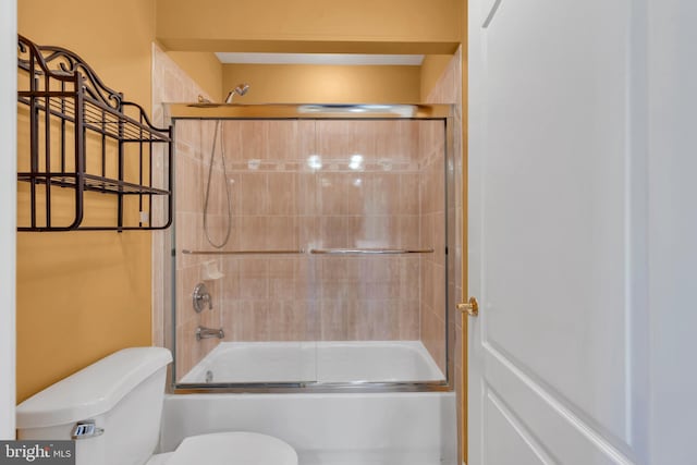 full bath featuring toilet and shower / bath combination with glass door