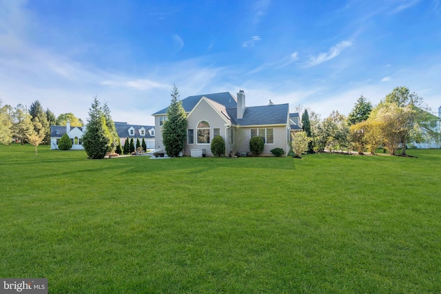 view of front facade featuring a front lawn and a chimney