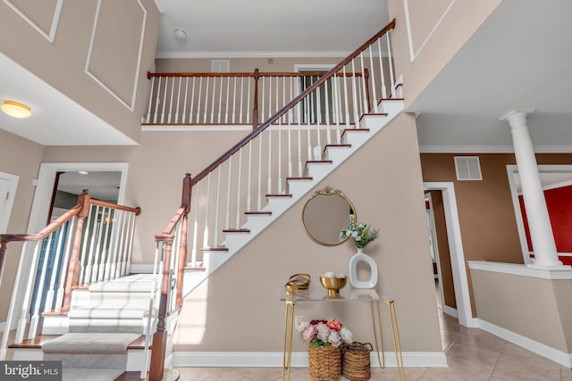 stairway featuring baseboards, decorative columns, and visible vents