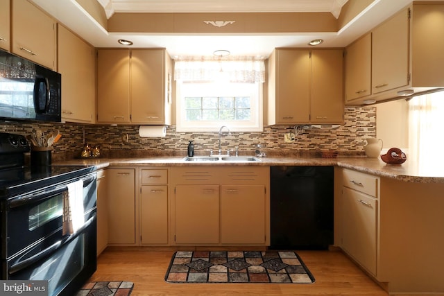 kitchen featuring crown molding, tasteful backsplash, a sink, black appliances, and light wood finished floors