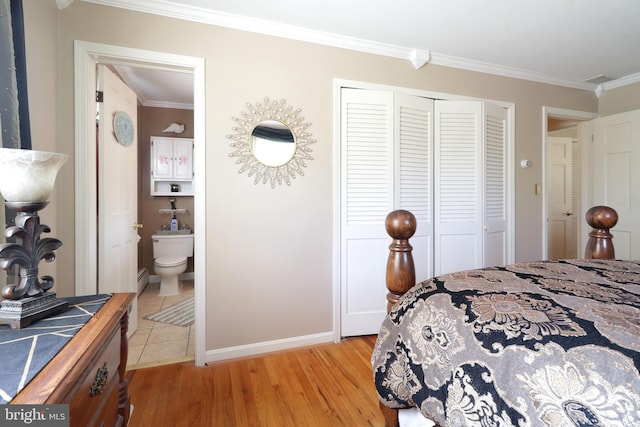 bedroom with connected bathroom, baseboards, light wood-type flooring, ornamental molding, and a closet