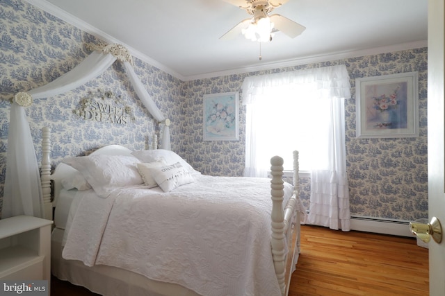 bedroom with ornamental molding, wood finished floors, baseboard heating, wallpapered walls, and a ceiling fan