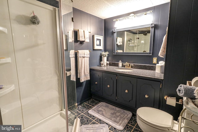 bathroom with vanity, a stall shower, and toilet