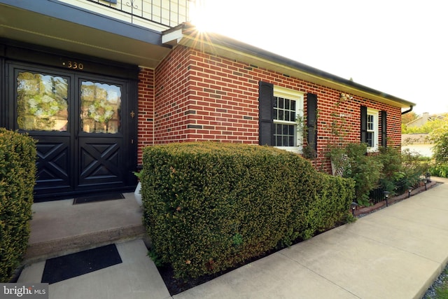 entrance to property featuring brick siding