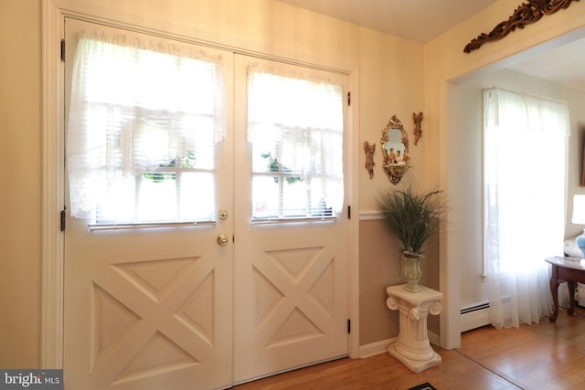entryway with baseboard heating and light wood-style floors
