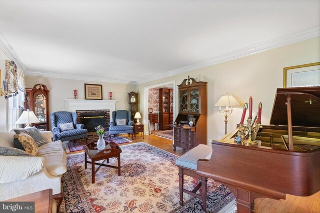 living area featuring crown molding, a fireplace, and wood finished floors
