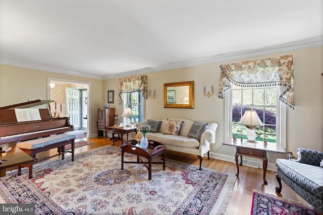 living room featuring crown molding, baseboards, visible vents, and wood finished floors