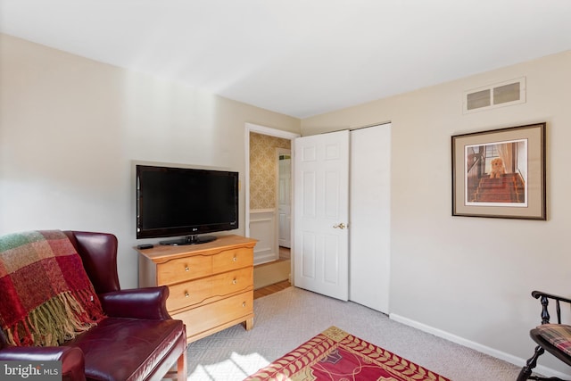 living area with visible vents and light carpet