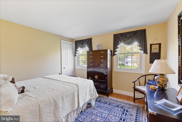 bedroom with baseboards and wood finished floors