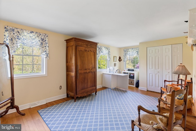 sitting room with baseboards, wood finished floors, and visible vents