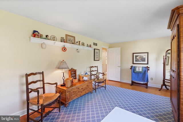 living area featuring visible vents, dark wood finished floors, and baseboards
