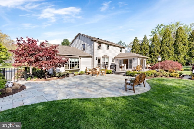 rear view of property featuring a patio area, fence, a yard, and roof with shingles