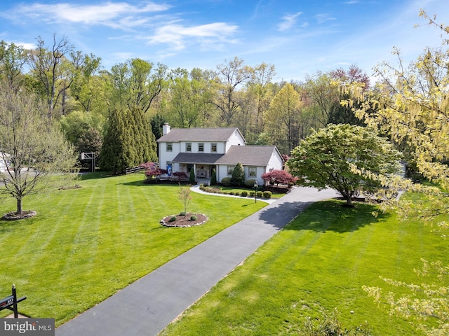 view of front of home featuring a front lawn and a chimney