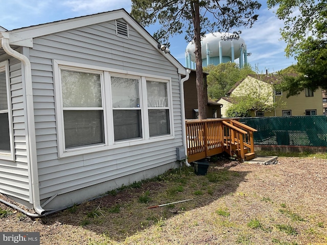 view of property exterior with fence and a wooden deck
