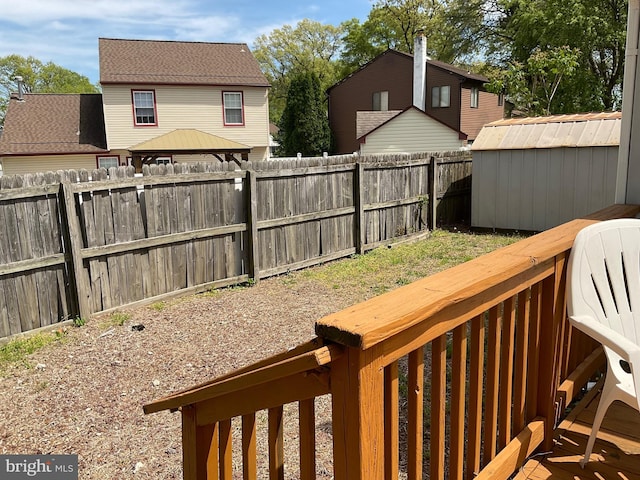 view of yard featuring a gazebo, a fenced backyard, a shed, and an outbuilding