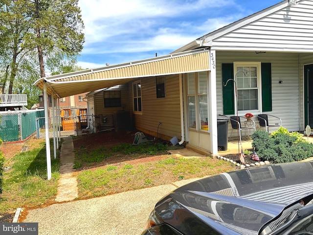 view of property exterior featuring fence and an attached carport