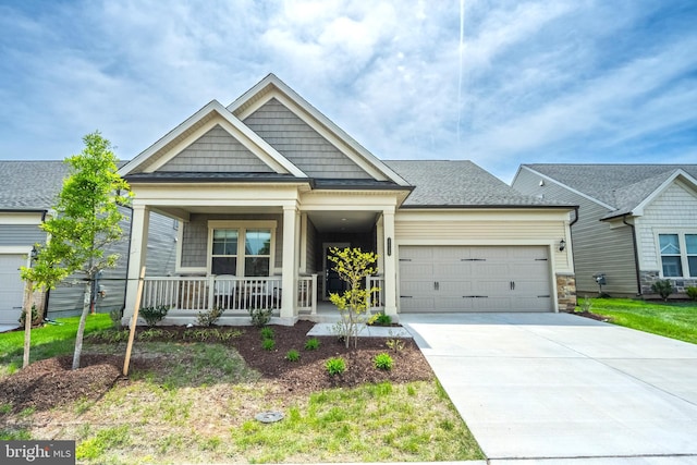 craftsman house featuring a porch, a garage, and concrete driveway