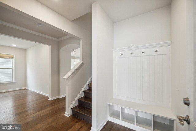 mudroom with baseboards, crown molding, and wood finished floors