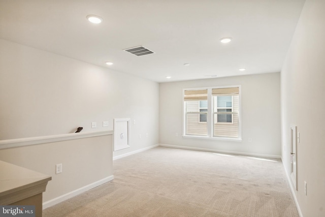 carpeted empty room featuring visible vents, recessed lighting, and baseboards