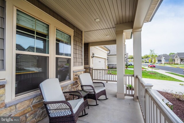 view of patio / terrace featuring covered porch, a residential view, and a garage