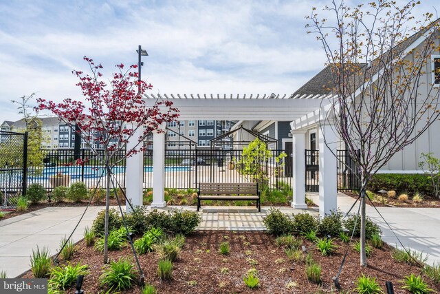 view of community featuring a swimming pool and fence