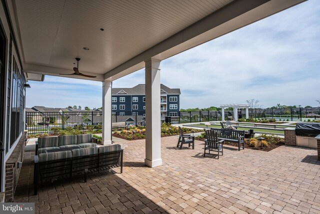 view of patio / terrace with ceiling fan, fence, and an outdoor living space