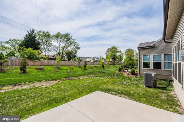 view of yard featuring fence, central AC unit, and a patio area