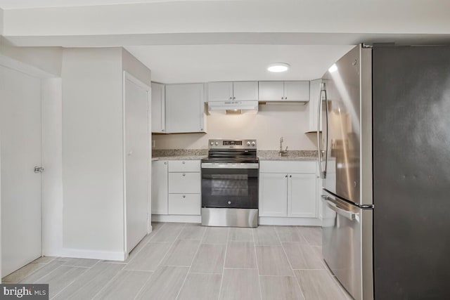 5018 Quimby Ave, Beltsville, MD 20705 - kitchen featuring stainless steel appliances, under cabinet range hood, white cabinets, light stone countertops, and a sink