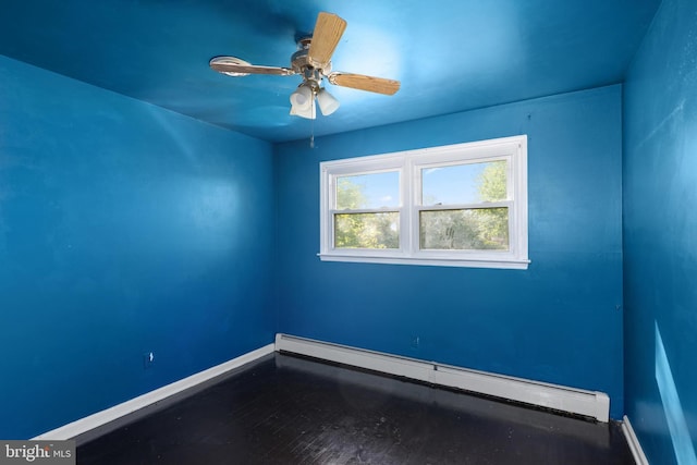 spare room featuring baseboards, ceiling fan, a baseboard heating unit, and wood finished floors