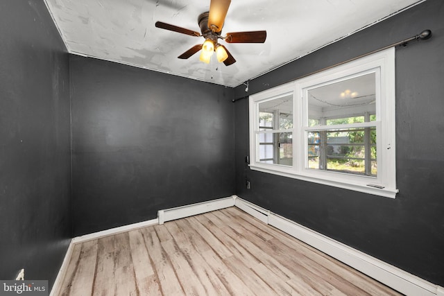unfurnished room featuring baseboards, a baseboard heating unit, ceiling fan, and wood finished floors
