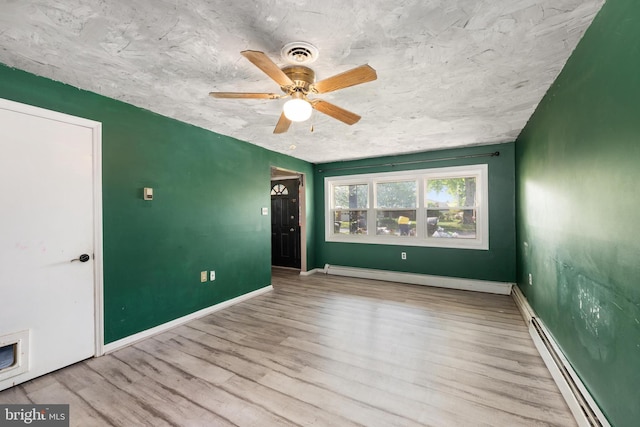 unfurnished room with baseboards, ceiling fan, wood finished floors, and a baseboard radiator