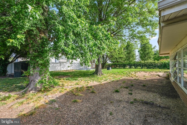 view of yard featuring an outdoor structure and fence