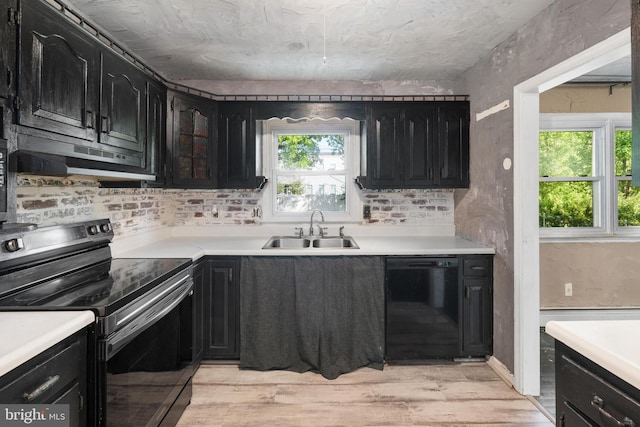 kitchen with dark cabinets, a sink, and black appliances