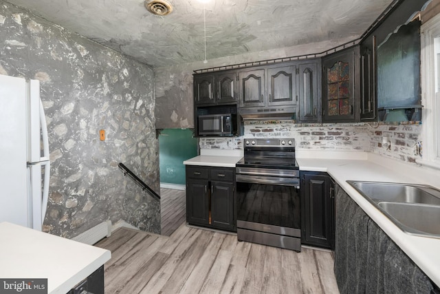 kitchen featuring visible vents, freestanding refrigerator, stainless steel range with electric stovetop, light wood-type flooring, and under cabinet range hood