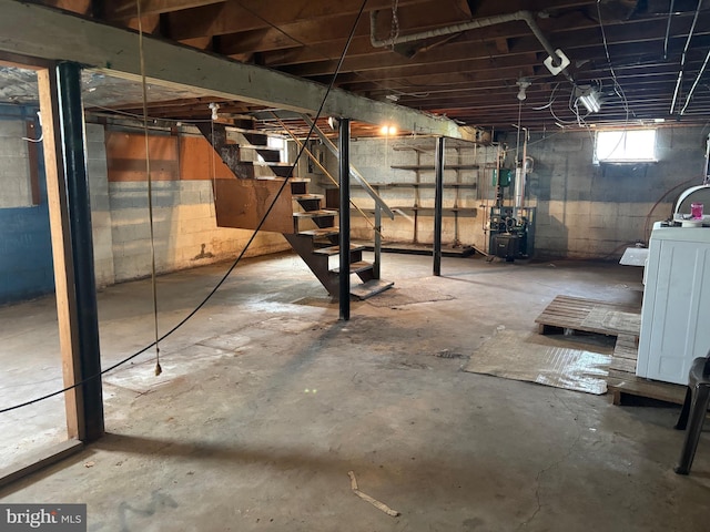 basement featuring washer / dryer, stairs, and a heating unit